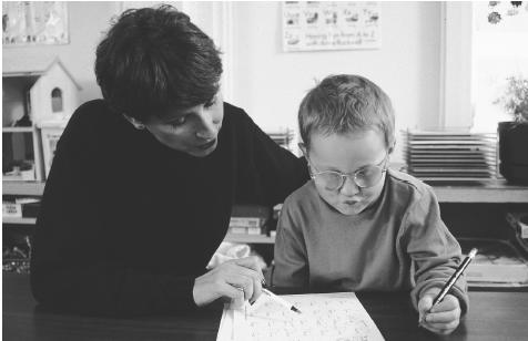 A special education teacher helps a student with attention-deficit/hyperactivity disorder with his math assignment.  (Photo Researchers, Inc. Reproduced by permission.)
