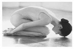 Woman in child's pose, a hatha yoga position. (Photo Researchers, Inc. Reproduced by permission.)